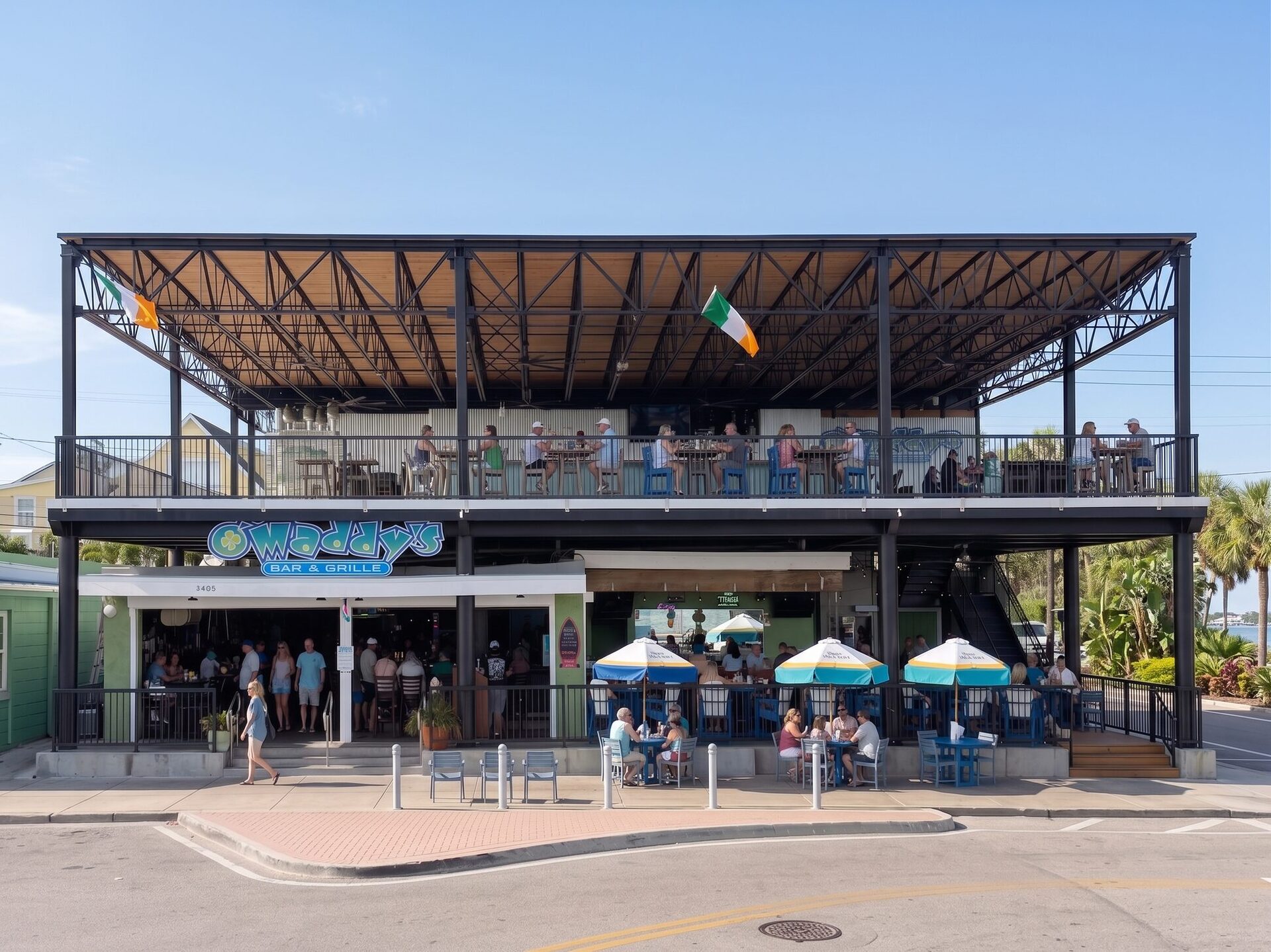 The two-story O'Maddy's Bar & Grille building with its covered upper deck and patio umbrellas, on a sunny day