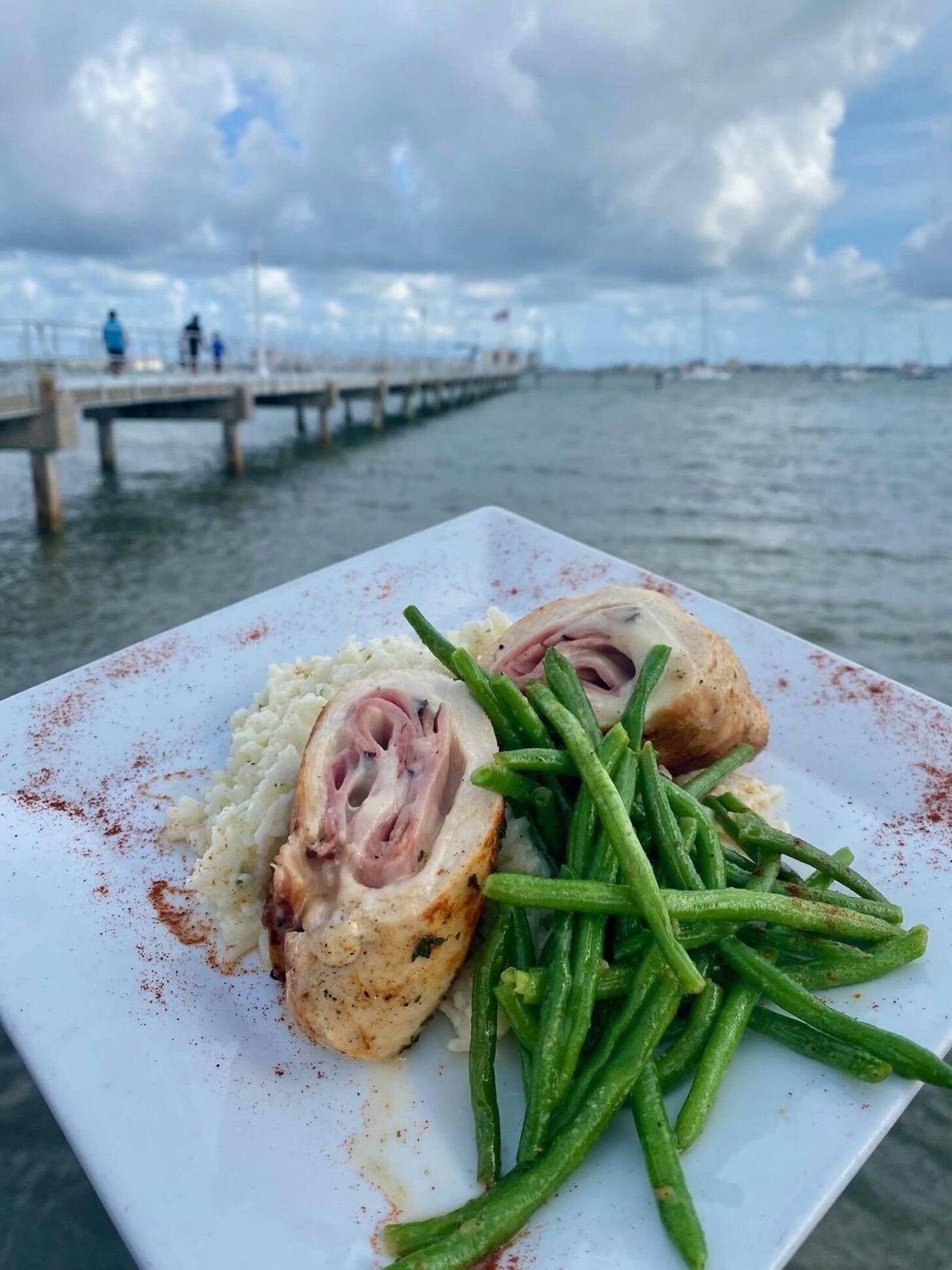 Chicken cordon bleu with green beans, with the Gulfport pier behind