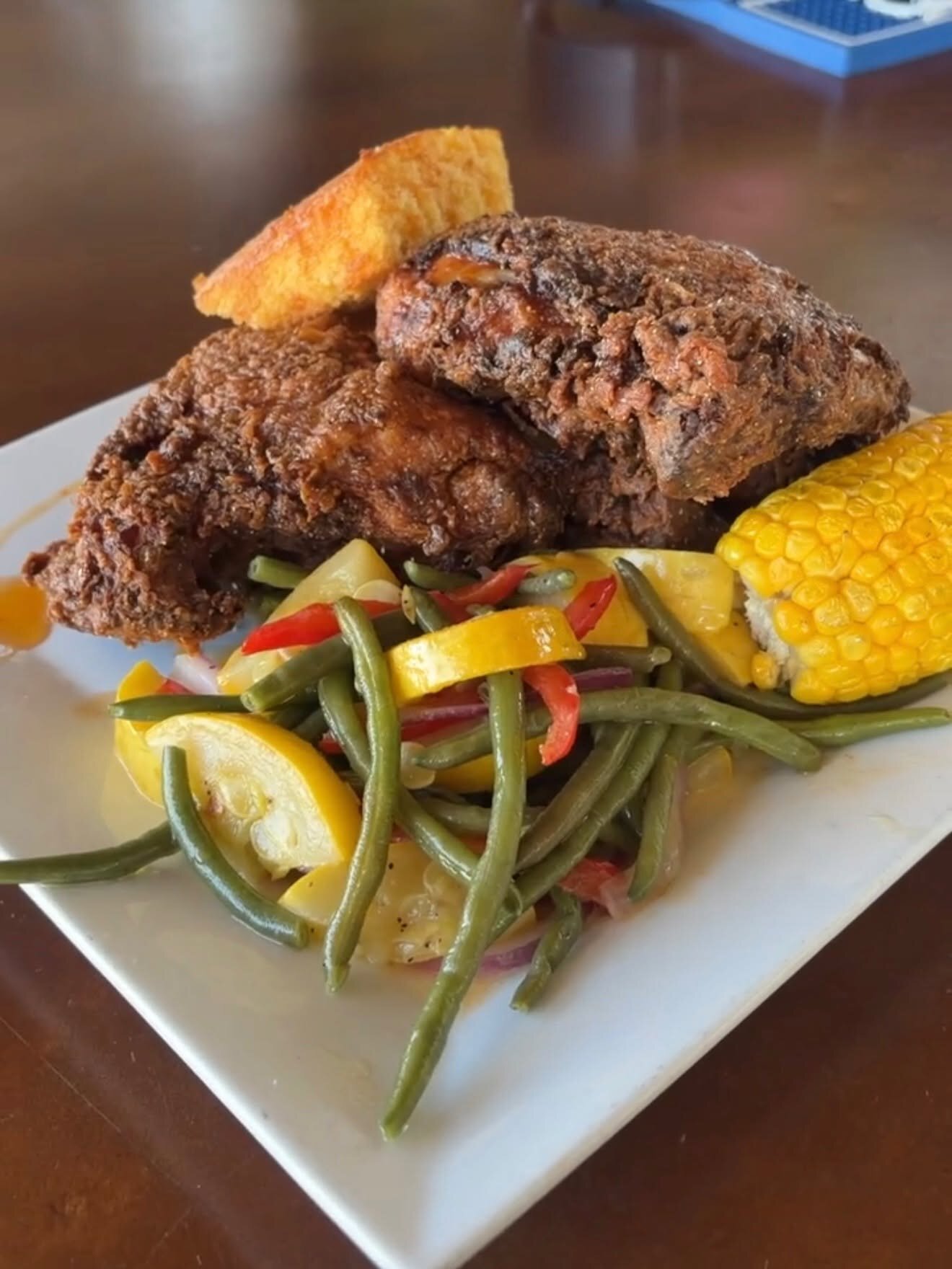 A blackened entree with corn and green beans