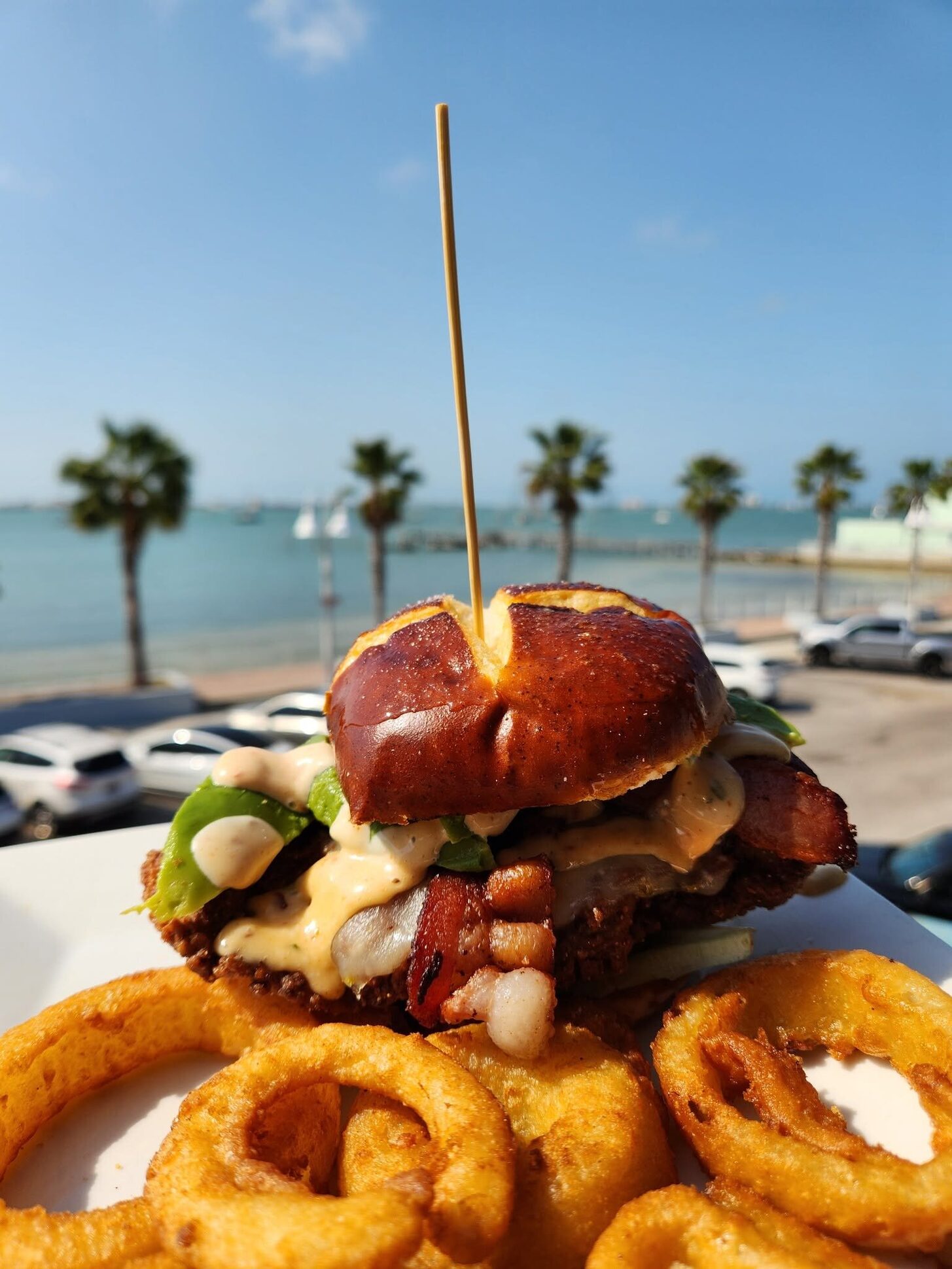 The Hangover burger on the O'Maddy's rail, with palms and Shore Blvd behind