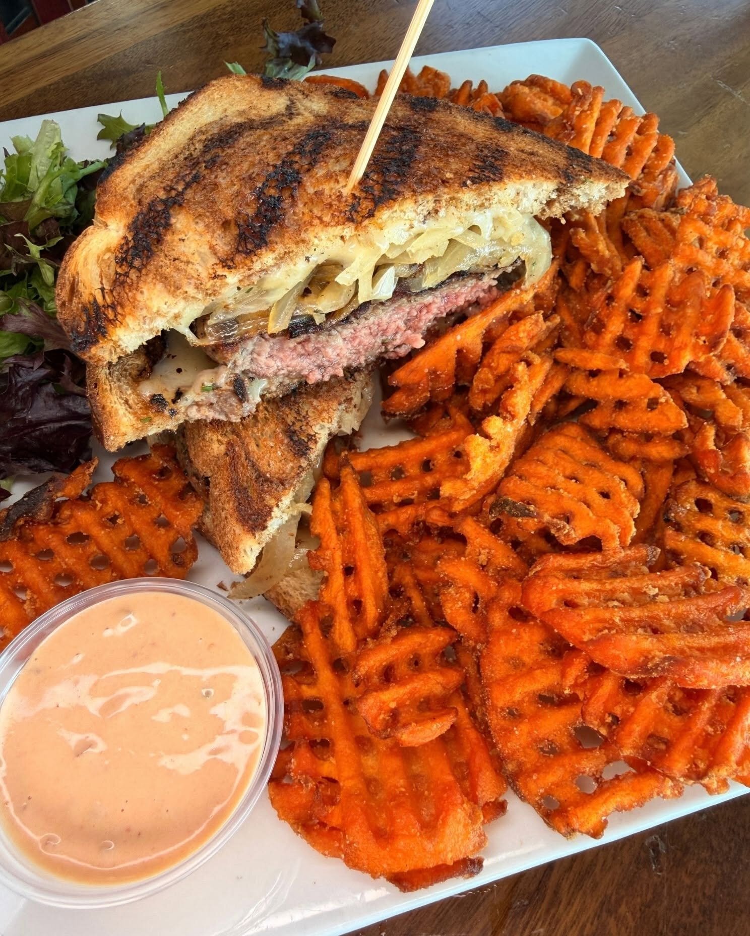 A patty melt with sweet potato waffle fries