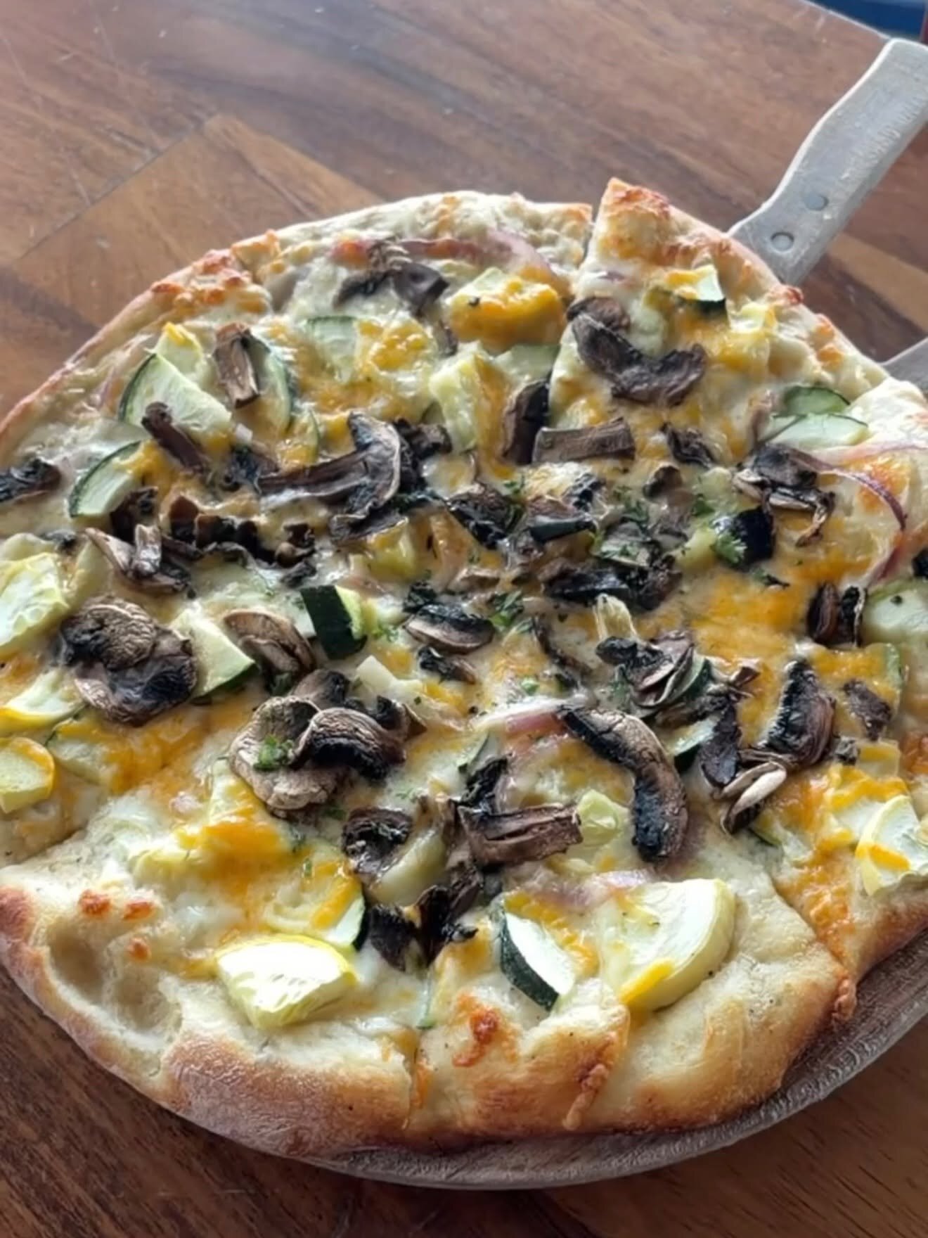 A veggie pizza on a wood board